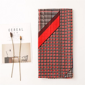Detailed view of houndstooth cotton linen scarf with red stripe and artistic background