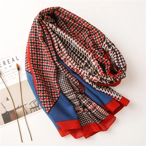 Detail of soft houndstooth linen scarf with red and blue patchwork pattern and textures