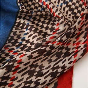Detailed view of houndstooth linen scarf with vibrant blue and red patchwork textures