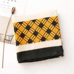 Detail shot of a yellow plaid linen-feel scarf featuring color-block geometric print patterns