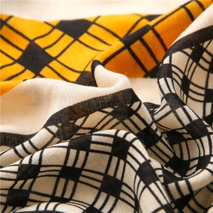 Detail of soft cotton-linen scarf showing the yellow and black plaid woven texture