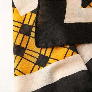Macro shot of geometric plaid scarf fabric showing fine stitching and soft linen texture