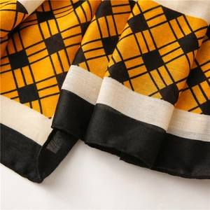 Detail of yellow and black geometric plaid scarf with premium overlock edge stitching