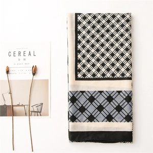 Detailed flat lay of a geometric diamond pattern cotton linen scarf with soft pastel tones