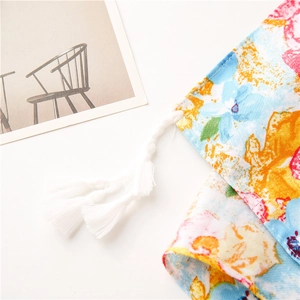 Detailed view of floral twill cotton fabric with vibrant oil painting style and tassels