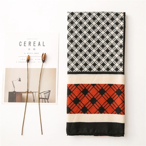 Close-up of geometric color block scarf with black and white plaid and orange patterns