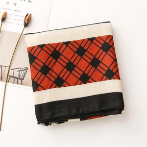 Flat lay of a red and black geometric plaid cotton-linen scarf with decorative props