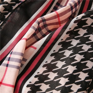 Macro view of houndstooth and striped cotton-linen scarf with red and blue plaid detail