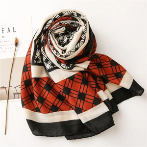 Detail of red and black plaid cotton linen scarf with elegant geometric fringe texture
