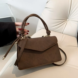 Minimalist dark brown crossbody bag with knotted handle and triangular flap closure