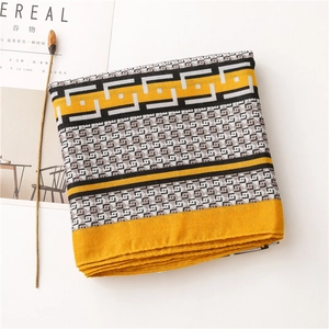 Detail of folded scarf with yellow geometric pattern and magazine as a prop