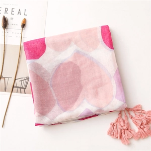 Dettaglio della sciarpa rosa con cuori, nappine decorative e tessuto traspirante fine