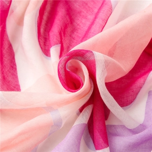 Dettaglio di una sciarpa in seta rosa e viola con trama leggera e colori vivaci