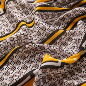 Macro detail of geometric print shawl showing fine mesh texture and yellow striped pattern