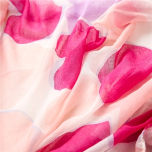 Dettaglio macro di uno scialle di seta rosa leggero con texture a fiori e strati