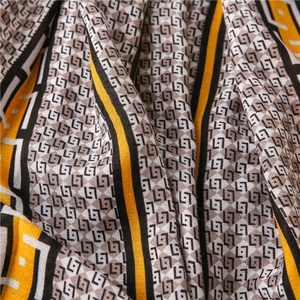 Macro shot of cotton linen scarf fabric with yellow and black geometric L7 letter prints