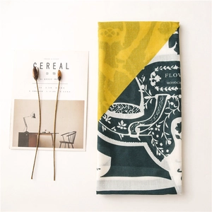 Flat lay of yellow and teal floral scarf with vintage patterns on white background