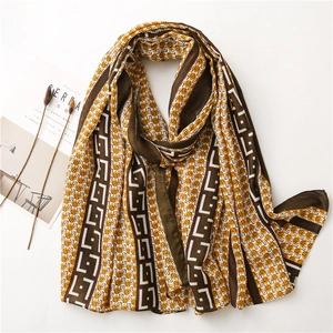 Close-up of geometric pattern scarf with mustard yellow and brown contrast borders