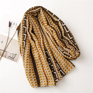 Detailed flat lay of a plaid knit shawl with chocolate brown and beige geometric patterns