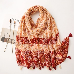 Detailed close-up of paisley pattern cotton scarf with fringe trim and autumn colors