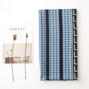 Flat lay of folded blue geometric scarf with stripe detail and aesthetic magazine decor