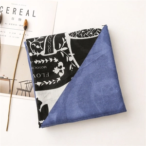 Detail of double-sided scarf with navy fleece and black-white baroque floral pattern