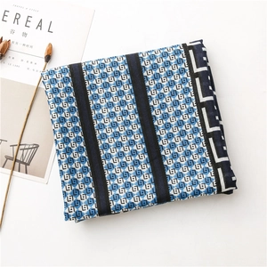 Detailed flat lay of a blue and black geometric pattern cotton linen scarf with fringe