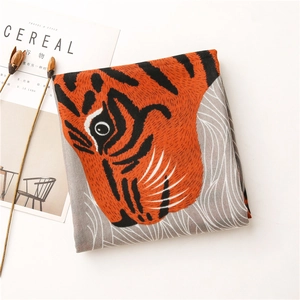 Détail d'une écharpe pliée avec imprimé tigre réaliste et motifs de vagues sur gris