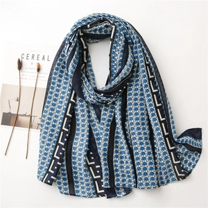 Detailed view of lightweight scarf with geometric patterns and navy blue stripes
