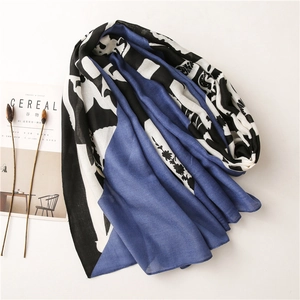 Close-up of lightweight scarf with blue color blocking and floral print on white background