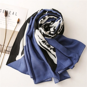 Detail of navy blue and white scarf with floral silhouette on a minimalist background