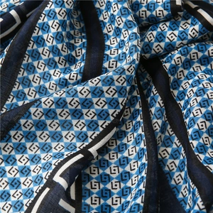 Close-up of geometric diamond pattern scarf fabric with blue and black artistic textures