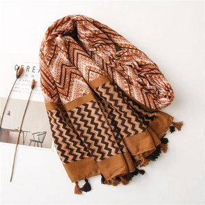 Detail of bohemian geometric scarf with earth-tone zigzag patterns and fringe edges