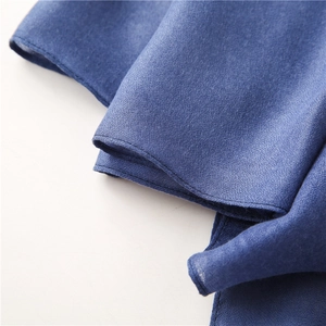Detail shot of the navy blue textured scarf fabric with neat machine-hemmed edges