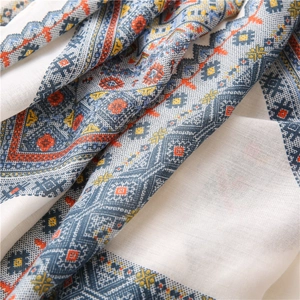 Détail du motif géométrique en losange sur le tissu doux en coton et lin de l'écharpe