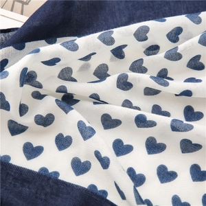 Detailed macro of a light cotton-linen scarf with navy heart prints and herringbone weave