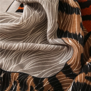 Détail d'une écharpe légère à imprimé léopard avec motifs abstraits et texture fine