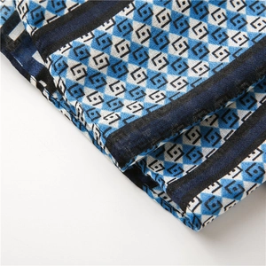 Detailed view of blue and white geometric diamond pattern fabric with navy border