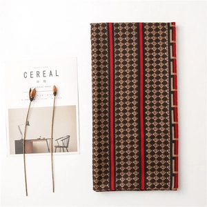 Detail of red and black geometric pattern scarf with stylish fringe and cereal magazine