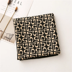 Detail of folded cotton-linen scarf with geometric letter pattern and chic decor