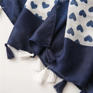 Detail view of cotton linen scarf showing blue heart patterns and herringbone weave texture