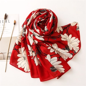 Detail of red floral scarf with white magnolia print on soft lightweight fabric