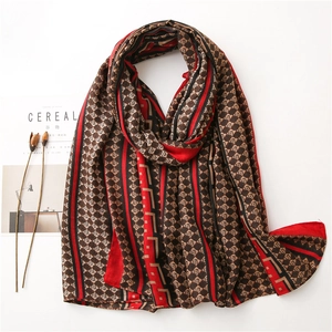 Detail of red and black geometric diamond pattern scarf with vintage Greek key border