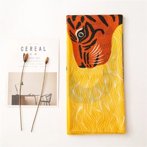 Détail d'un châle à imprimé tigre avec motifs de vagues jaunes et texture douce