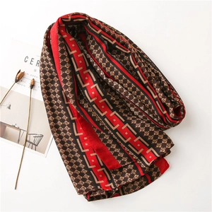 Detail of red and brown geometric scarf with elegant draped silk-like texture