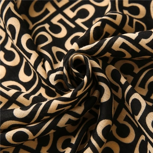 Macro shot of cotton linen scarf texture featuring repeated number 5 pattern in black and beige