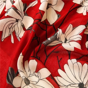 Close-up of floral print fabric with white blossoms on a vibrant red background scarf