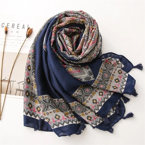 Écharpe en lin bleu marine à motifs losanges géométriques et pompons sur fond blanc