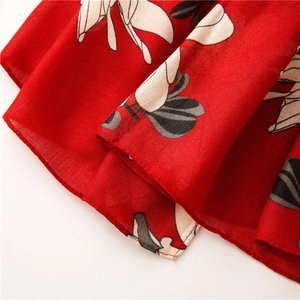 Detail of red floral scarf showing high-quality chiffon fabric and rolled hem stitching