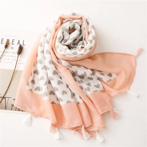 Detail of pink and white heart pattern cotton scarf with decorative tassels